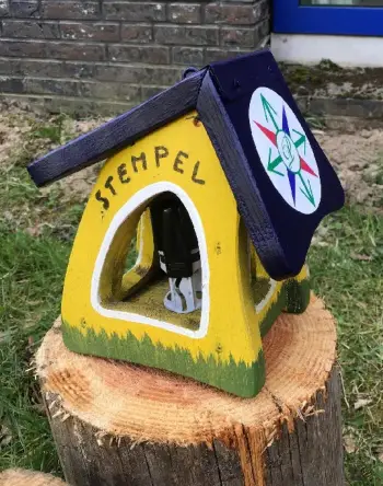 Stempelpost met een geel vogelhuisje als stempelbus.